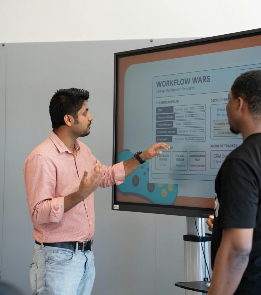 Two professionals engage in a workflow strategy discussion using a screen display.